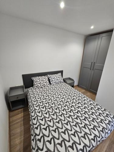 a bedroom with a bed with a black and white comforter at Confort House in Argentona