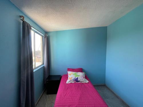 a blue room with a bed with a pink blanket at Room in El Crucero in Silao