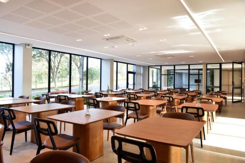 a dining room with tables and chairs and windows at Vallér Parque Hotel Executive in Lajeado