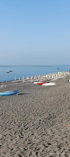 a beach with a bunch of birds and boats on it at Casa fronte mare in Roccalumera