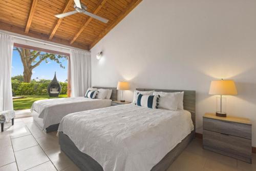 two beds in a bedroom with a window at Villa with golf course views in San Rafael del Yuma