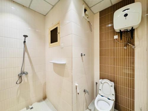 un baño con inodoro y ducha en رفاء الذهبية للشقق المخدومة, en Al Makhwāh