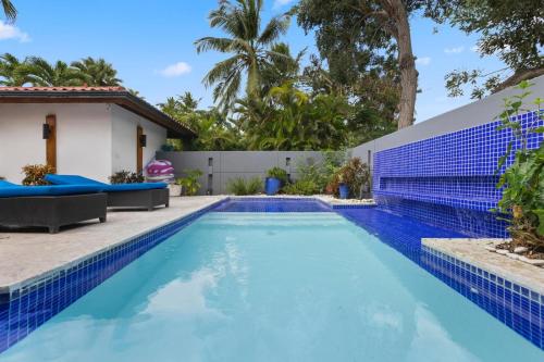a swimming pool in a backyard with a house at Villa with golf course views in San Rafael del Yuma