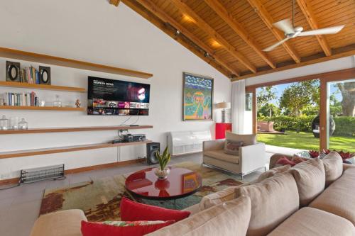 a living room with a couch and a tv at Villa with golf course views in San Rafael del Yuma
