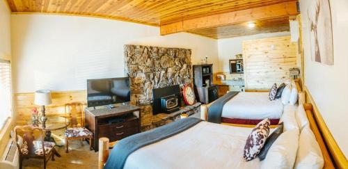 a bedroom with two beds and a stone wall at River Lodge in Island Park