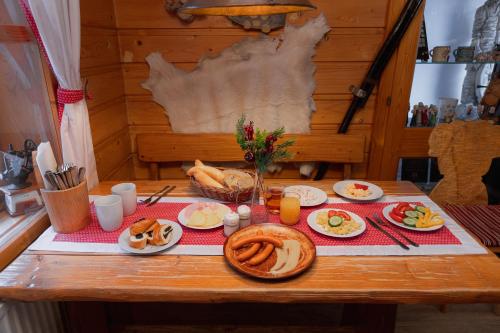 a table with plates of food on it at Wellness rezort Jánošíkov dvor in Zázrivá