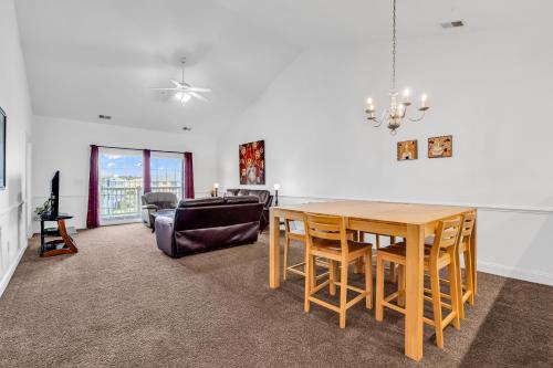 a dining room with a table and a couch at Myrtlewood by Monarch Rentals in Myrtle Beach
