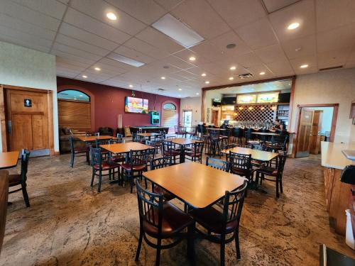 a dining room with tables and chairs in a restaurant at Ramada by Wyndham Strasburg Dover in Strasburg