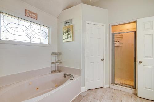 a white bathroom with a tub and a window at Residential Cul-De-Sac Suburban Memphis Hideaway! in Lakeland