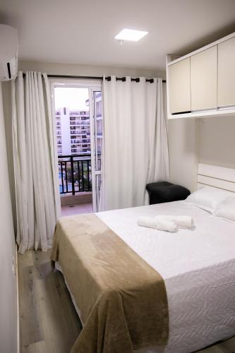 a bedroom with a large white bed and a window at Apart-hotel Resort Taguatinga, Brasília in Taguatinga