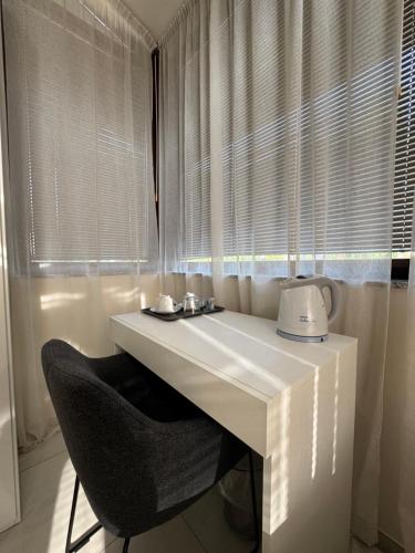a white table with a chair in front of a window at B&B Orio Affittacamere Foresteria Lombarda in Grassobbio