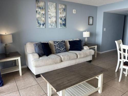 a living room with a couch and a table at Hosteeva Ocean Forest Plaza w Beachview Balcony in Myrtle Beach