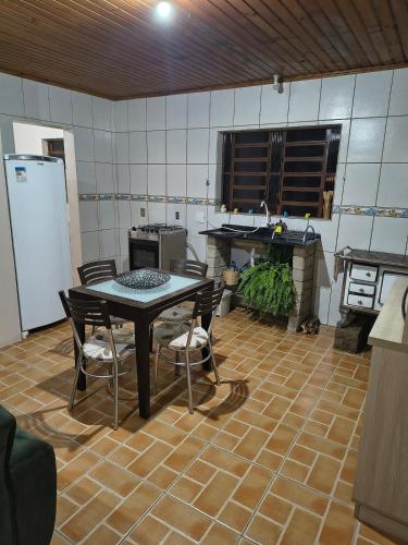 a kitchen with a table and chairs in a room at Guest house on the property in Gramado