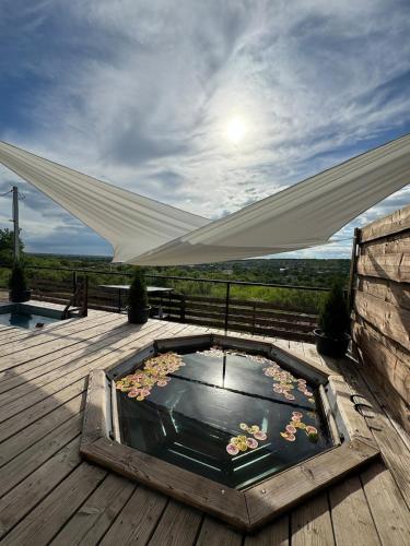 a pool of water on a wooden deck with a canopy at Shalash 1 in Velikiye Lazy