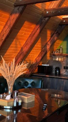 a bar with wooden ceilings and a table with books at Shalash 1 in Velikiye Lazy