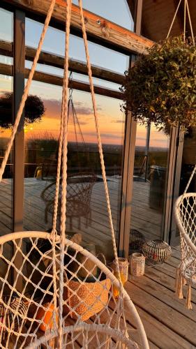 a rope swing on a porch with a sunset in the background at Shalash 1 in Velikiye Lazy