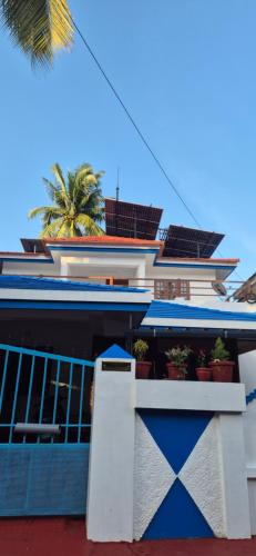 a blue and white building with potted plants on it at Brundhavan - Peaceful villa in Kottayam in Kottayam