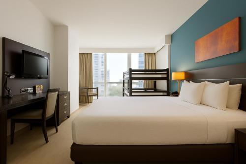 a bedroom with a bed and a desk and a television at Tryp by Wyndham Panama Centro in Panama City