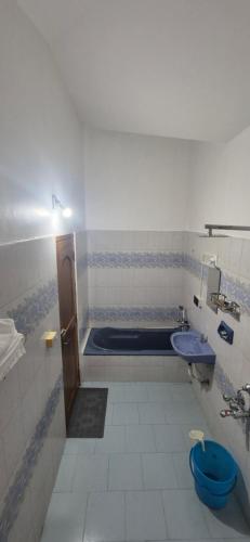 a bathroom with a tub and a toilet and a sink at Brundhavan - Peaceful villa in Kottayam in Kottayam