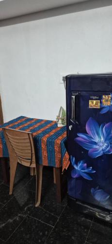 a room with a table and a microwave with flowers on it at Brundhavan - Peaceful villa in Kottayam in Kottayam
