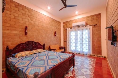 a bedroom with a bed and a brick wall at Shell Park in Kanyakumari
