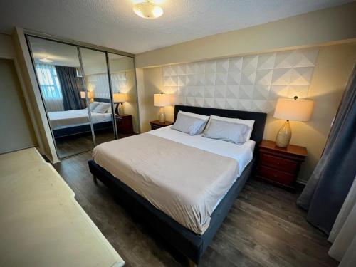 a bedroom with a large bed and a mirror at Lower Penthouse Suite with Pools & Sunset Views in Toronto