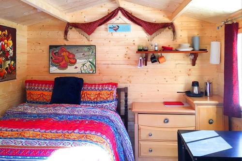 パースにあるGlamping at the Cabinのベッドと木の壁がある寝室