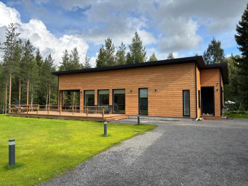 een groot houten huis met een groot terras bij Villa Snowy Owl in Rovaniemi