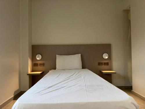 een slaapkamer met een wit bed met twee lampen erop bij Viaje Hotel Downtown Cairo in Caïro