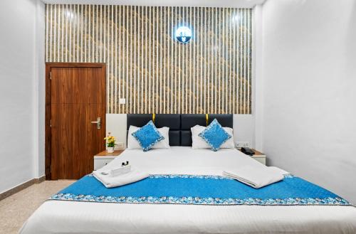 a bedroom with a large bed with blue pillows at Hotel Ramay Palace 400 Meter from Ram Mandir Ayodhya in Ayodhya