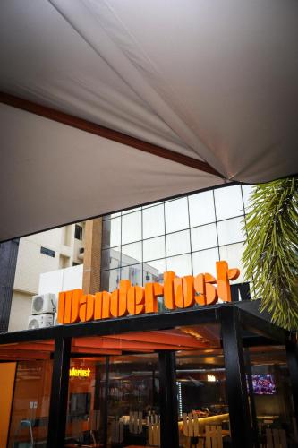 an orange sign on the front of a restaurant at Wanderlust Hostel in Maceió