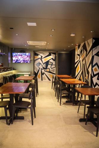 a dining room with wooden tables and chairs at Wanderlust Hostel in Maceió