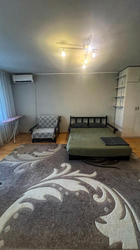a bedroom with two beds and a couch in it at Квартира на Казахстан 72 in Ustʼ-Kamenogorsk