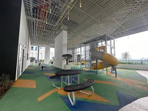 a room with two tables and a slide at Alinea suites Luxury near by shah alam in Shah Alam