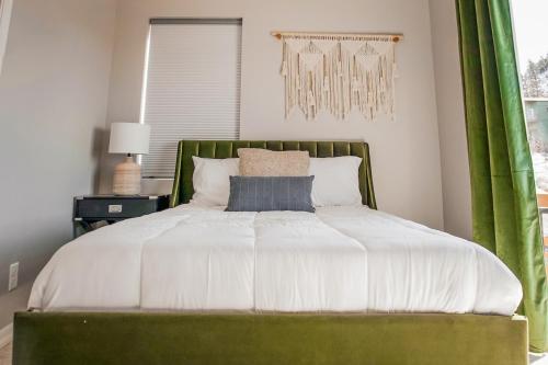 a bedroom with a large bed with a green headboard at The Pine House in Flagstaff