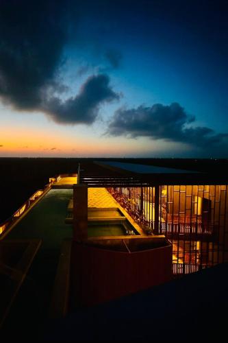 a view of a building at night with the sky at Jungle Guardian - Rooftop Pool & Beach Club in Zona Hotelera Tulum in Tulum