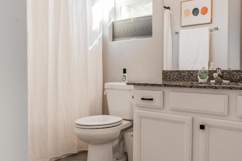 a white bathroom with a toilet and a sink at The Pine House in Flagstaff