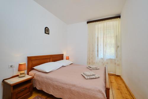 a bedroom with a bed with two towels on it at Kapetanova kuća in Martinšćica