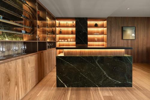 a kitchen with a black marble counter and wooden cabinets at Presidente InterContinental Monterrey by IHG in Monterrey
