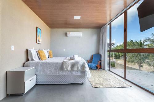 een slaapkamer met een bed en een groot raam bij Piscina e serviço incluído na Rota dos Milagres in Tatuamunha