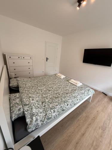 a bedroom with a bed and a flat screen tv at Apartament przy plaży Rogowo in Rogowo