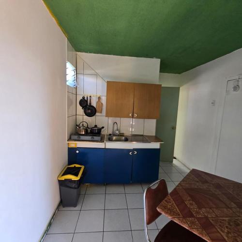a small kitchen with blue cabinets and a green ceiling at Resimed in Antofagasta
