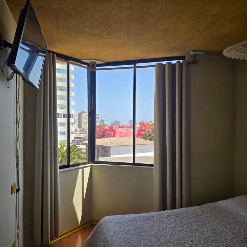 a bedroom with a bed and a large window at Resimed in Antofagasta