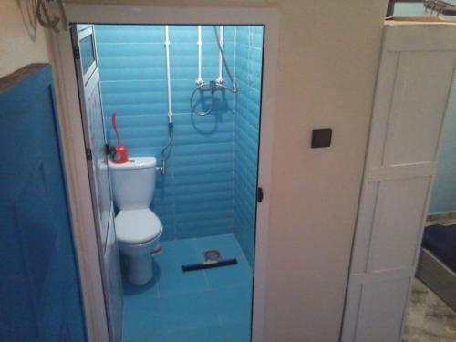 - une salle de bains avec toilettes dans une pièce bleue dans l'établissement Twin double comfy room tamtetoucht, à Tamtetoucht