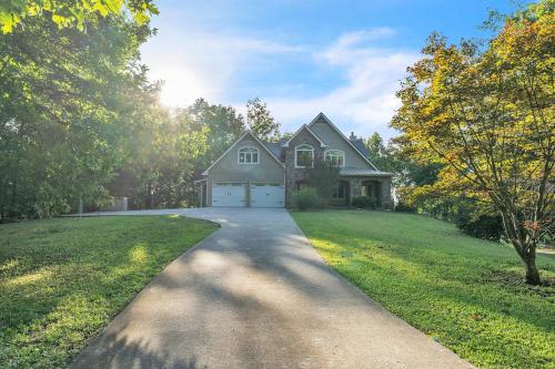 eine Auffahrt, die zu einem Haus mit einer Garage führt in der Unterkunft The Retreat at Wildwood - Hot Tub Theater & Deck in Wildwood