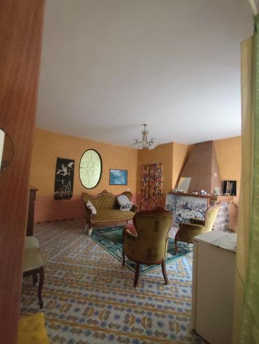 a living room with a couch and chairs in a room at Casa Pesce Rooms Rent in Serrara Fontana