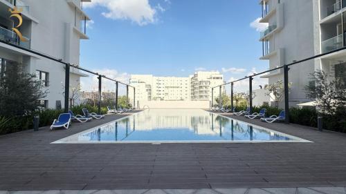 a swimming pool in the middle of a building at Elegant 1BR Blossom Retreat - Masdar City in Abu Dhabi