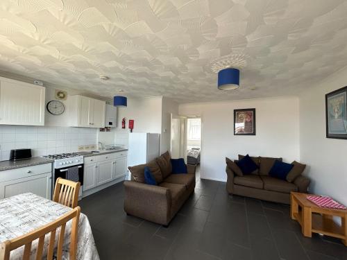 a kitchen and living room with a couch and a table at 76 Brambles Chine, 2 bedroom bungalow in beautiful holiday village, 1 night stays and Ferry travel offer available in Isle of Wight