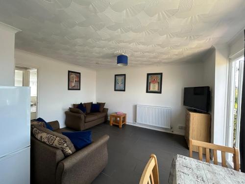 a living room with a couch and a tv at 76 Brambles Chine, 2 bedroom bungalow in beautiful holiday village, 1 night stays and Ferry travel offer available in Isle of Wight