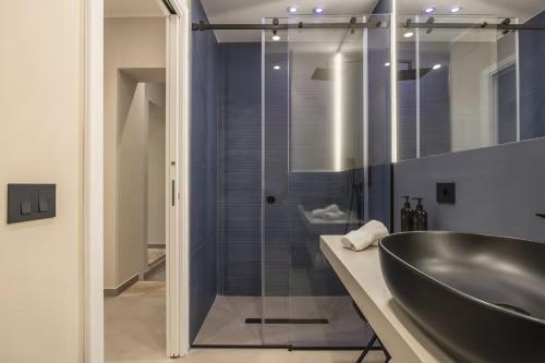 Un baño con lavabo y ducha de cristal. en Lolli Boutique & SPA Mondello, en Palermo